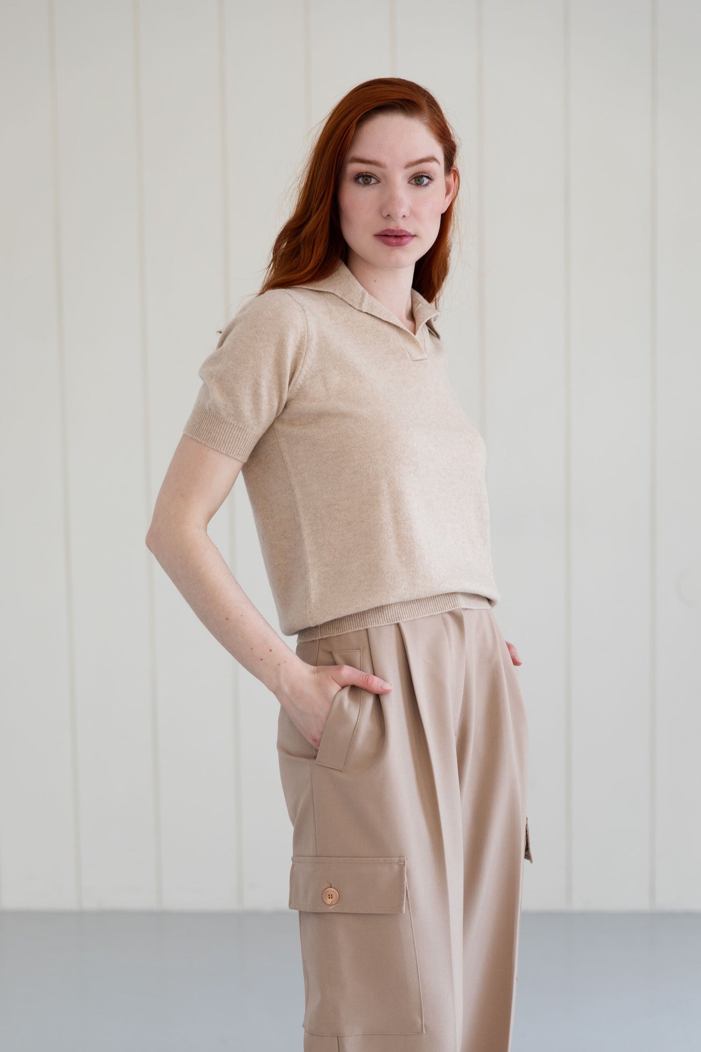 Woman wearing a beige cashmere polo shirt and cargo pants