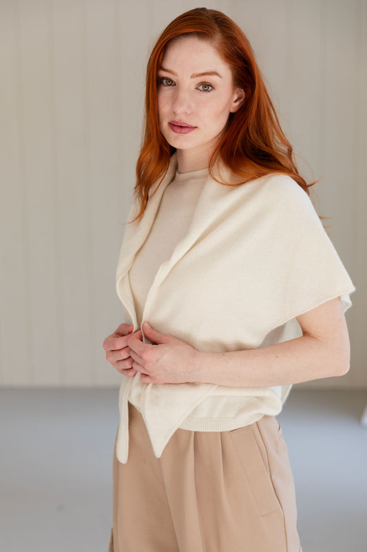 Woman wearing a white cashmere triangle scarf and beige trousers