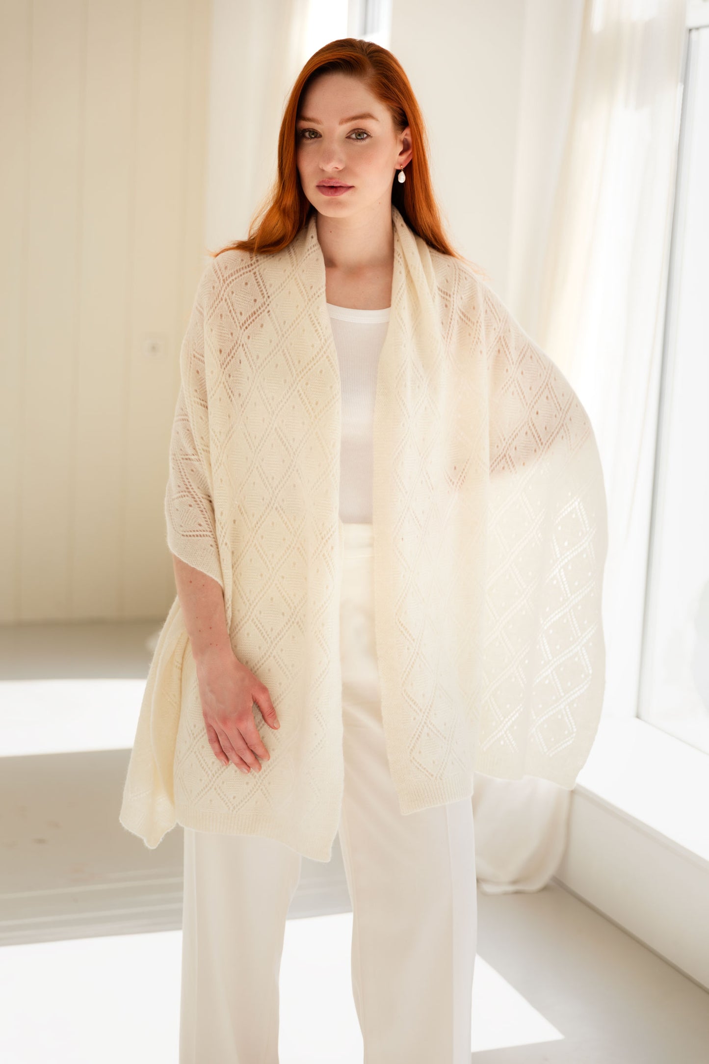 Woman wearing a white 100% Mongolian cashmere pointelle shawl.