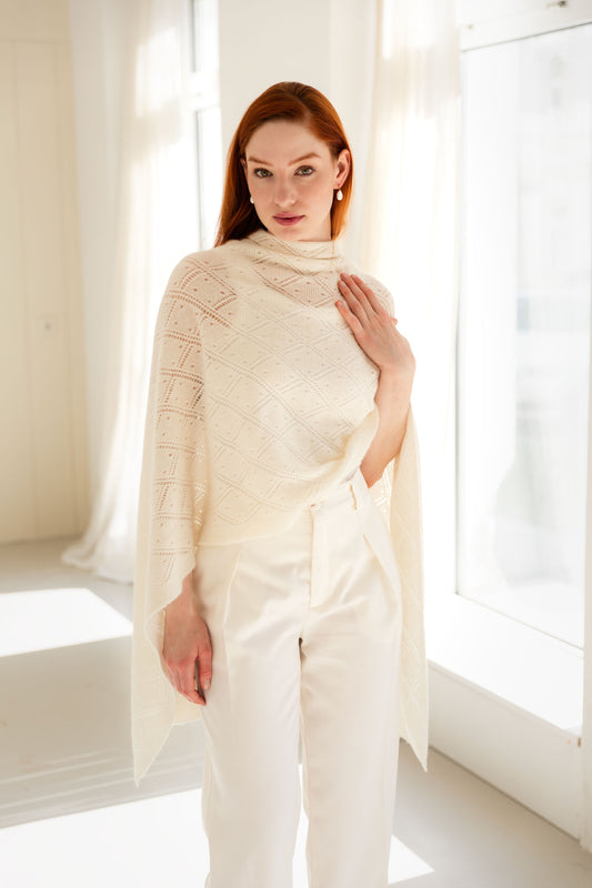 Woman wearing a white lace cashmere shawl in a bright room