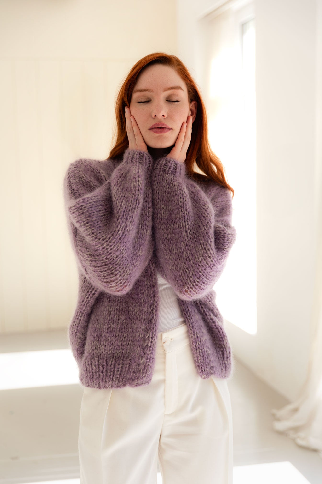 Woman wearing a lilac mohair-silk cardigan in a bright room