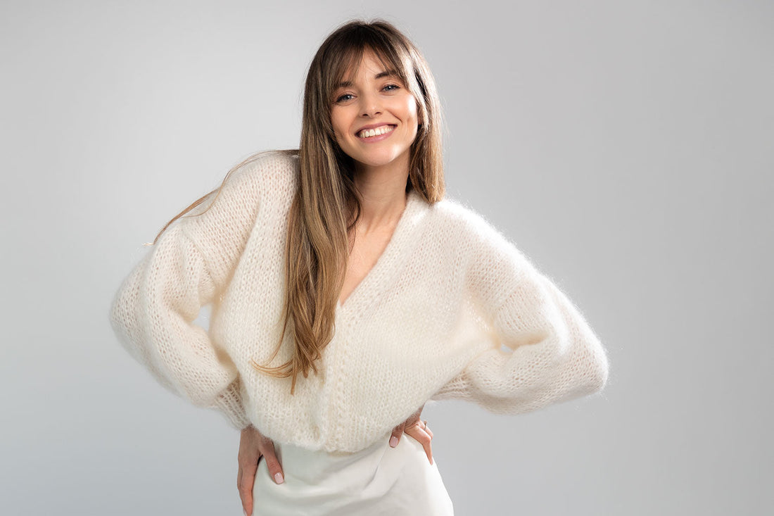 Woman wearing a white mohair cardigan over a silk dress