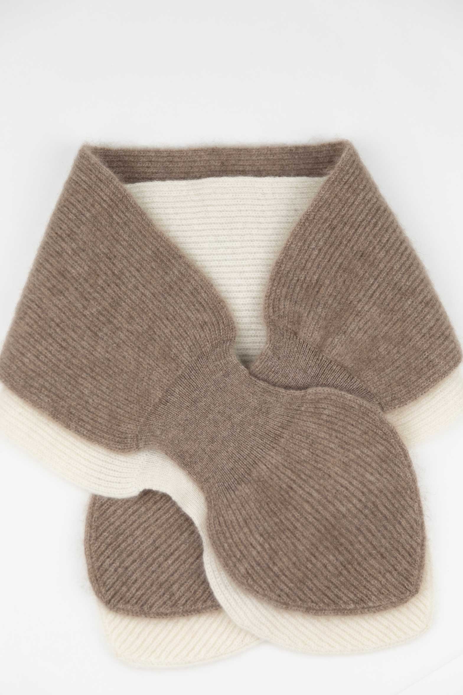 Close-up of a Taupe cashmere mini scarf layered over a Natural White version, demonstrating the secure loop fastening and elegant ribbed hem.