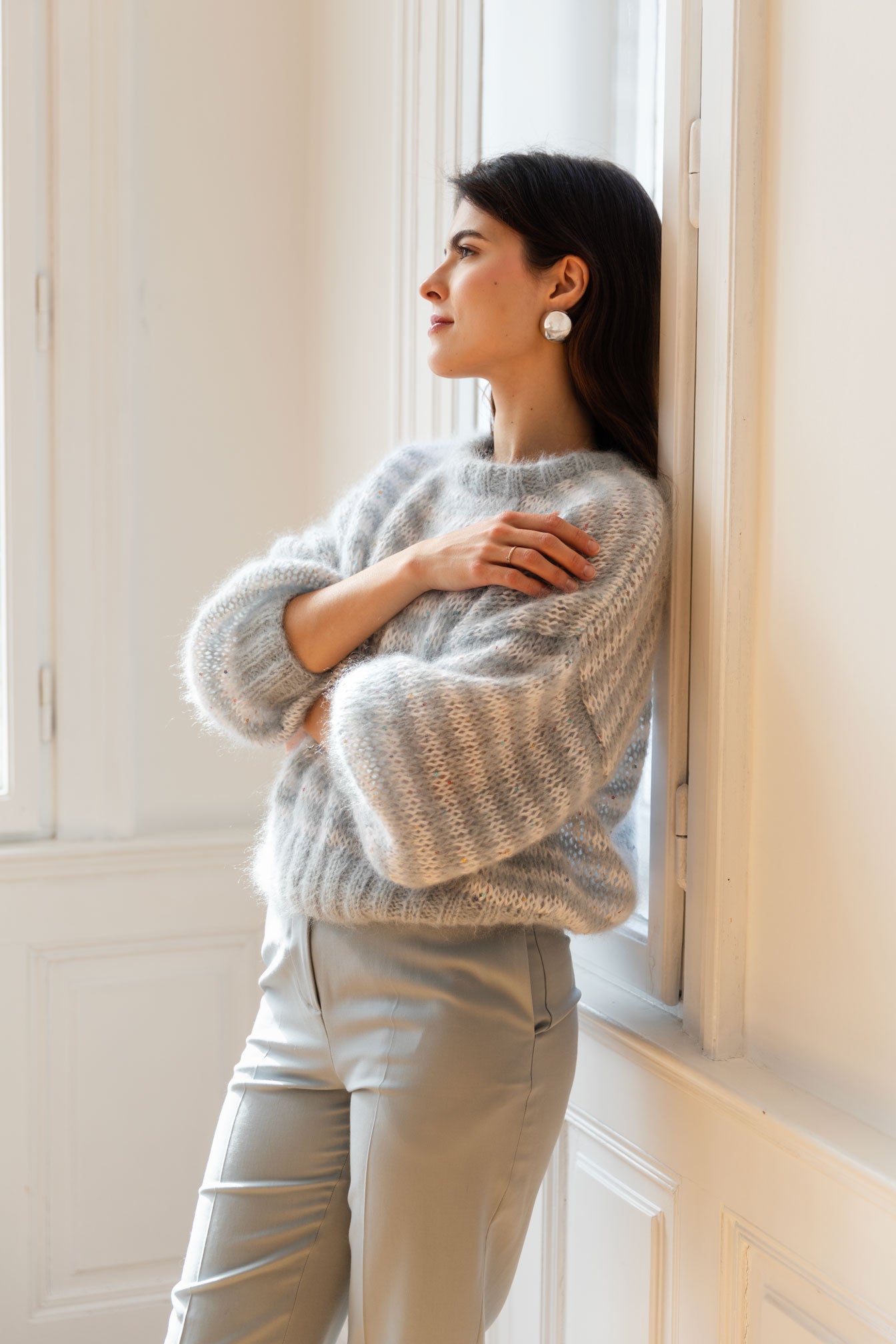 Woman wearing a striped mohair sweater in blue and white, paired with blue trousers