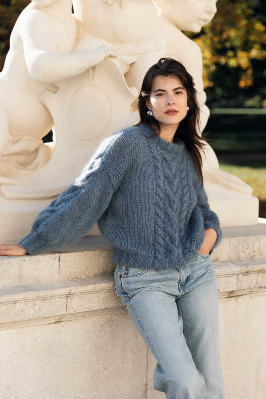 Woman wearing a blue mohair sweater and light blue jeans.
