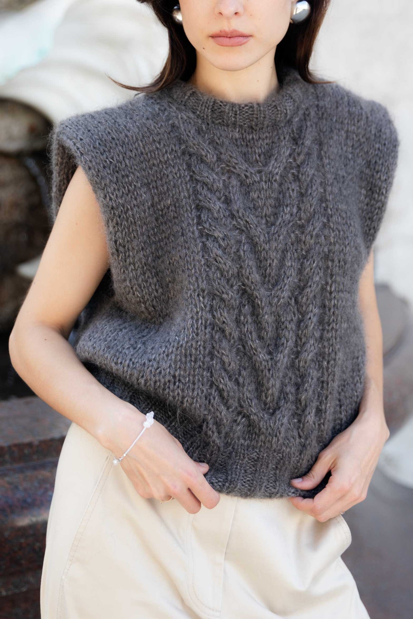 Woman wearing a fluffy mohair vest with cable knit pattern