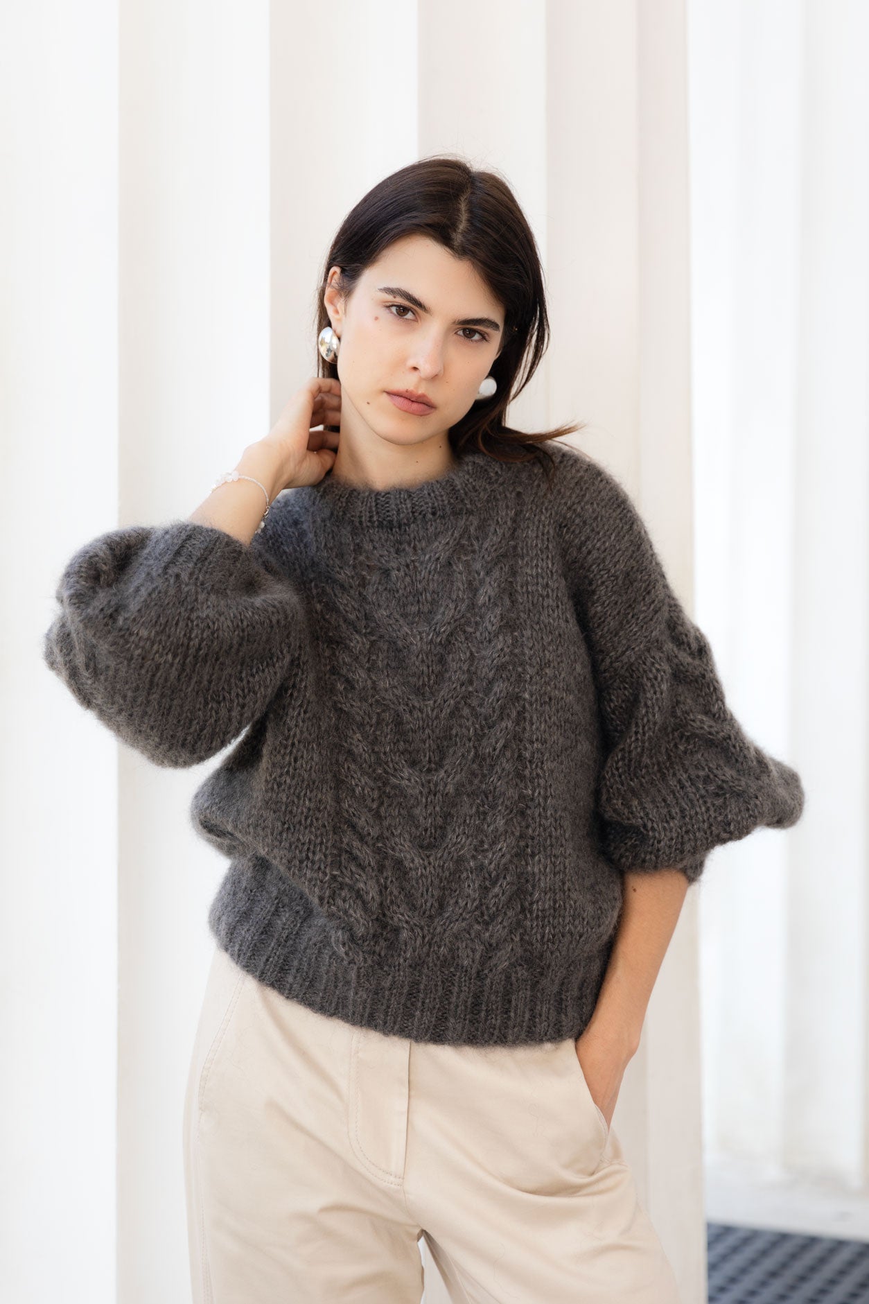 Woman wearing a brown mohair sweater with artisanal cable details