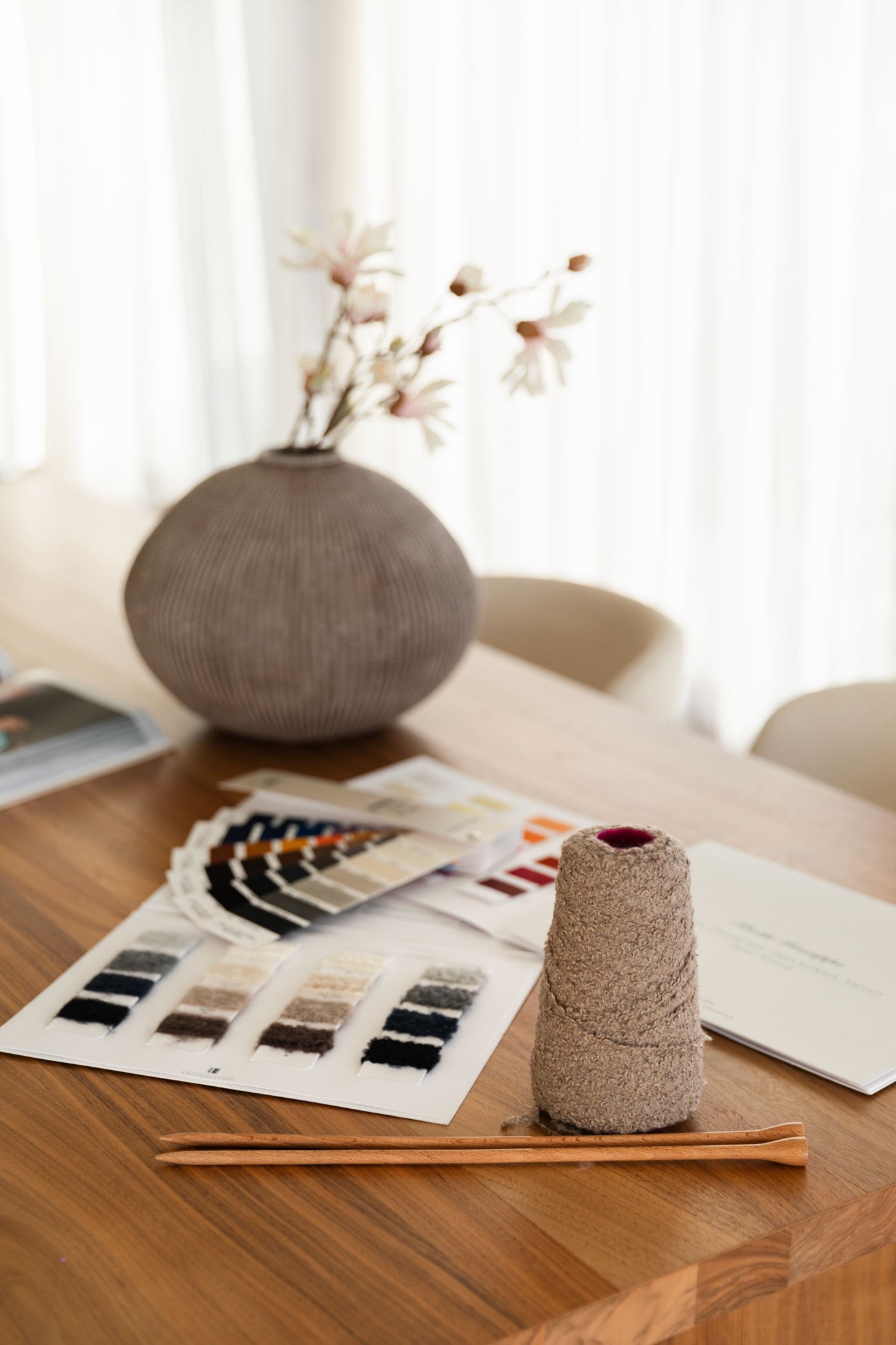 Knitting colour swatches and a cashmere cone  on a table in an elegant setting