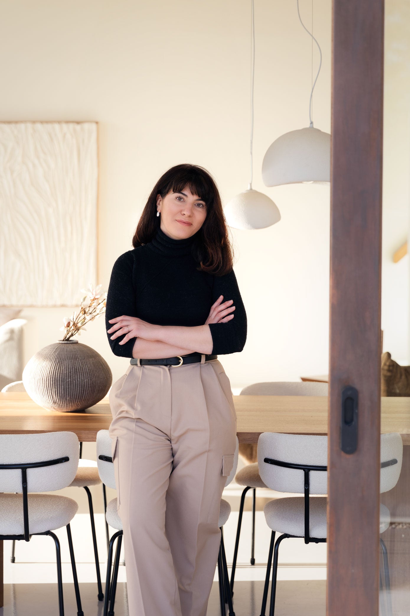 Onika Knitwear founder and designer standing in a modern interior setting with neutral tones