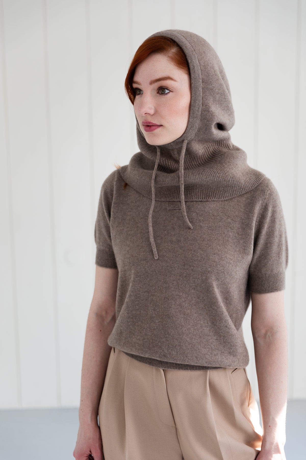 Woman wearing a beige 100% Mongolian cashmere balaclava, paired with similar short sleeve top.