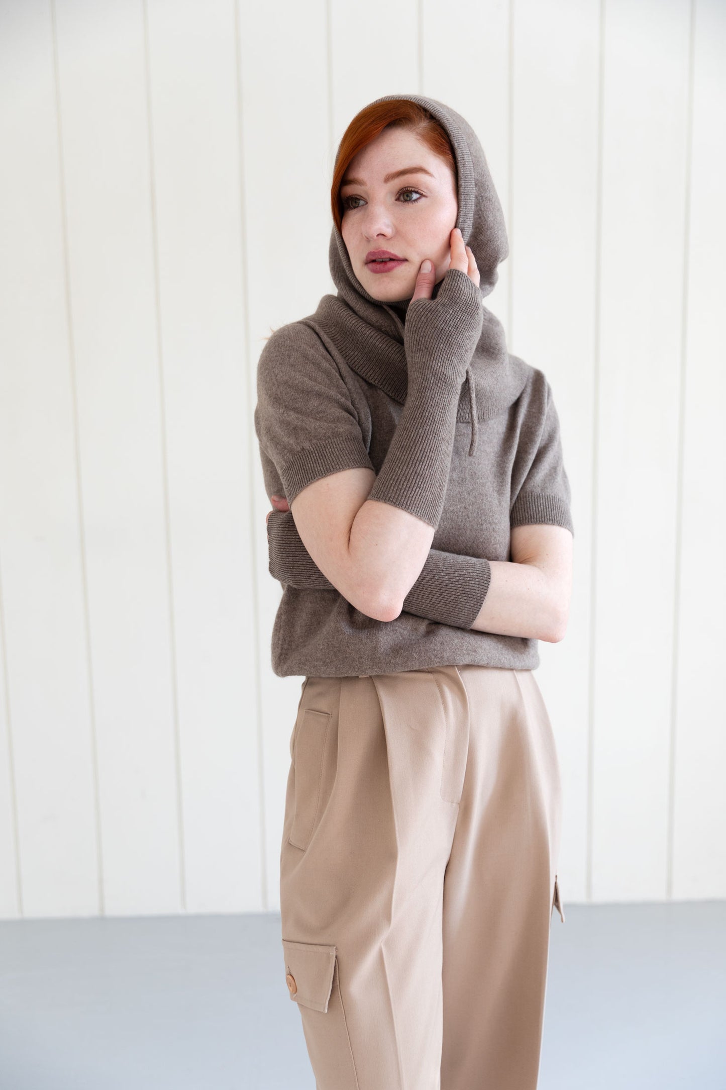 Woman wearing a brown cashmere balaclava, and matching cashmere arm warmers and cashmere short sleeve top