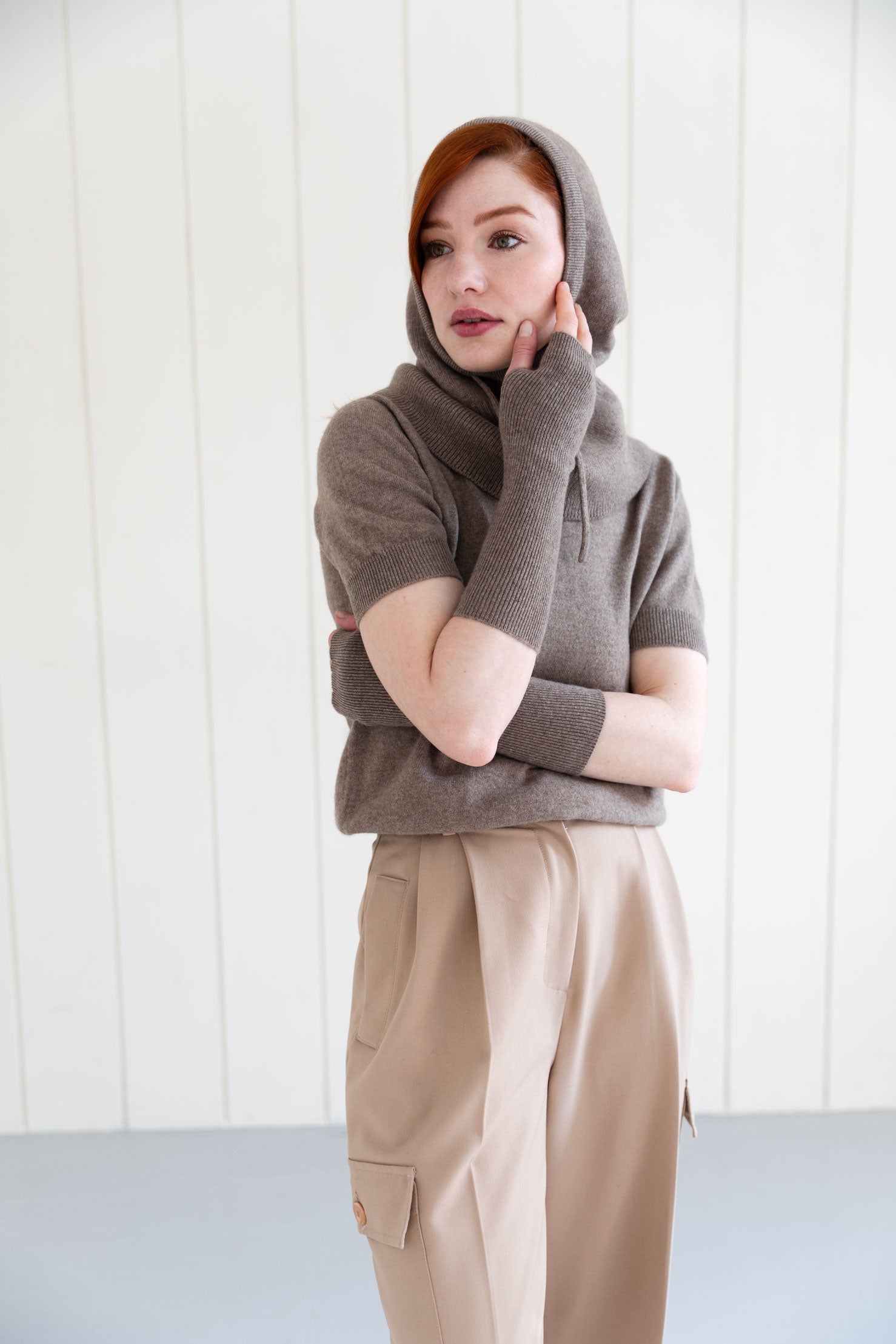 Woman wearing a brown cashmere balaclava, and matching cashmere arm warmers and cashmere short sleeve top