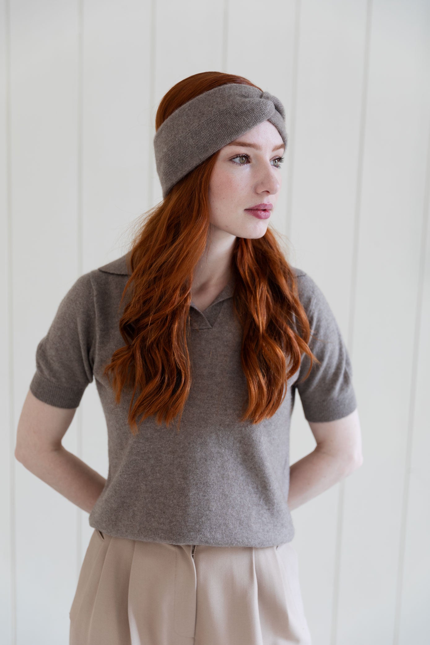 Woman wearing a taupe cashmere headband and matching cashmere top.