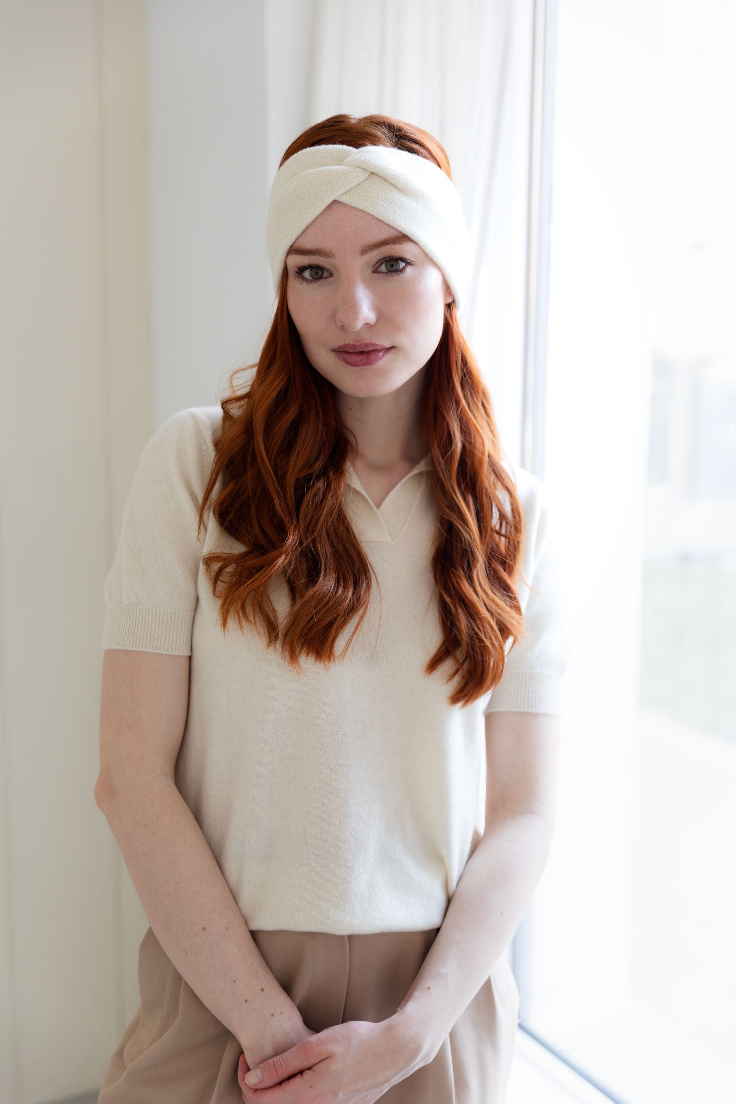 Woman wearing a white cashmere headband and cashmere top