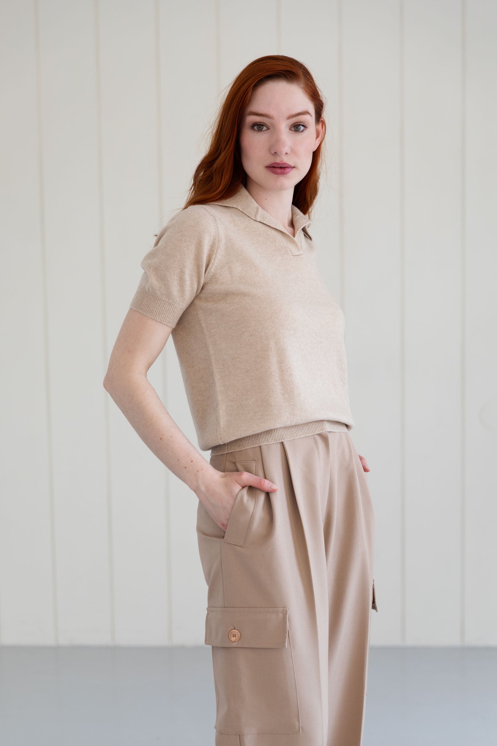 Woman wearing a beige cashmere polo shirt and cargo pants