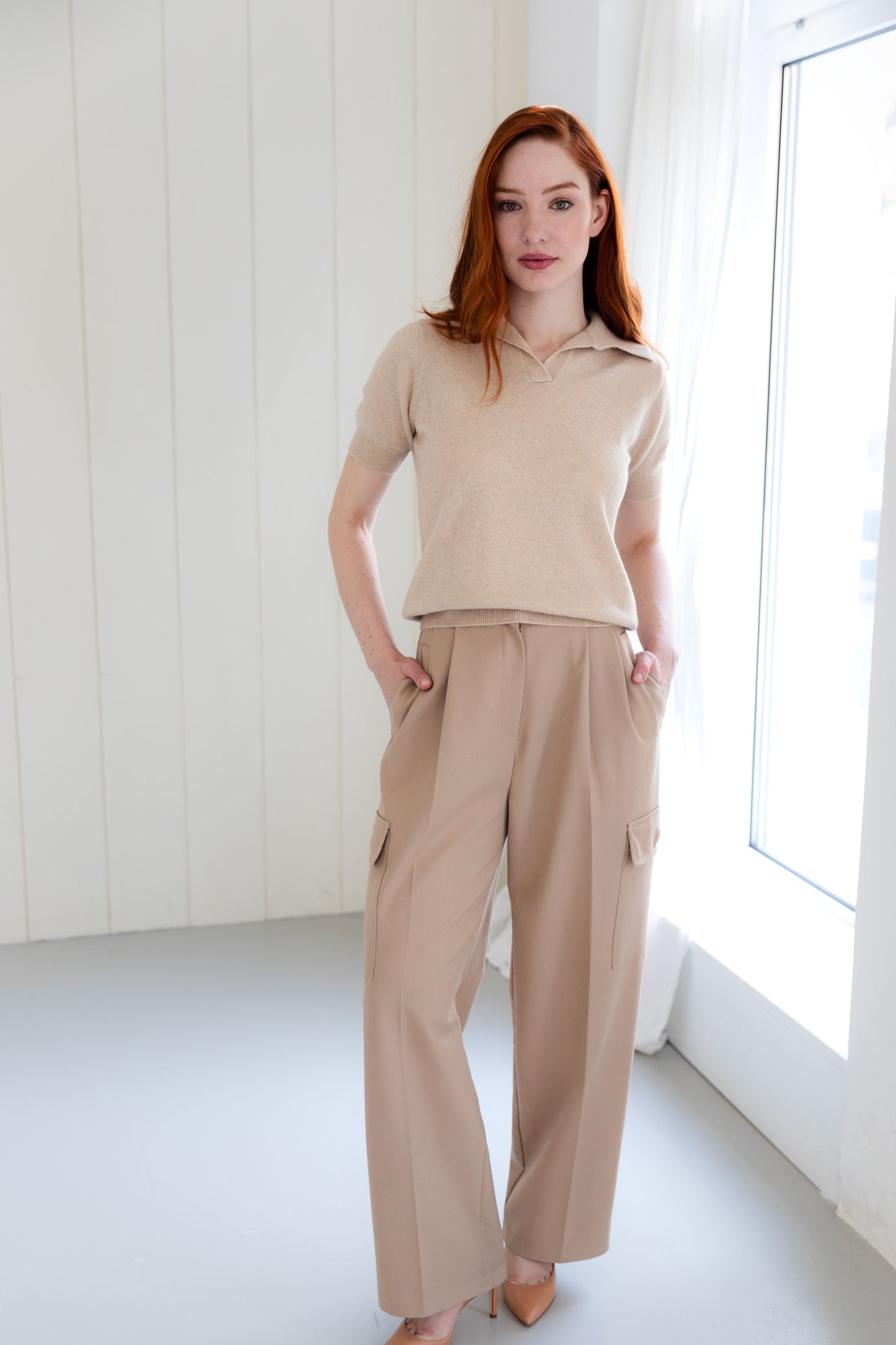 Woman wearing a beige cashmere polo shirt and beige cargo pants