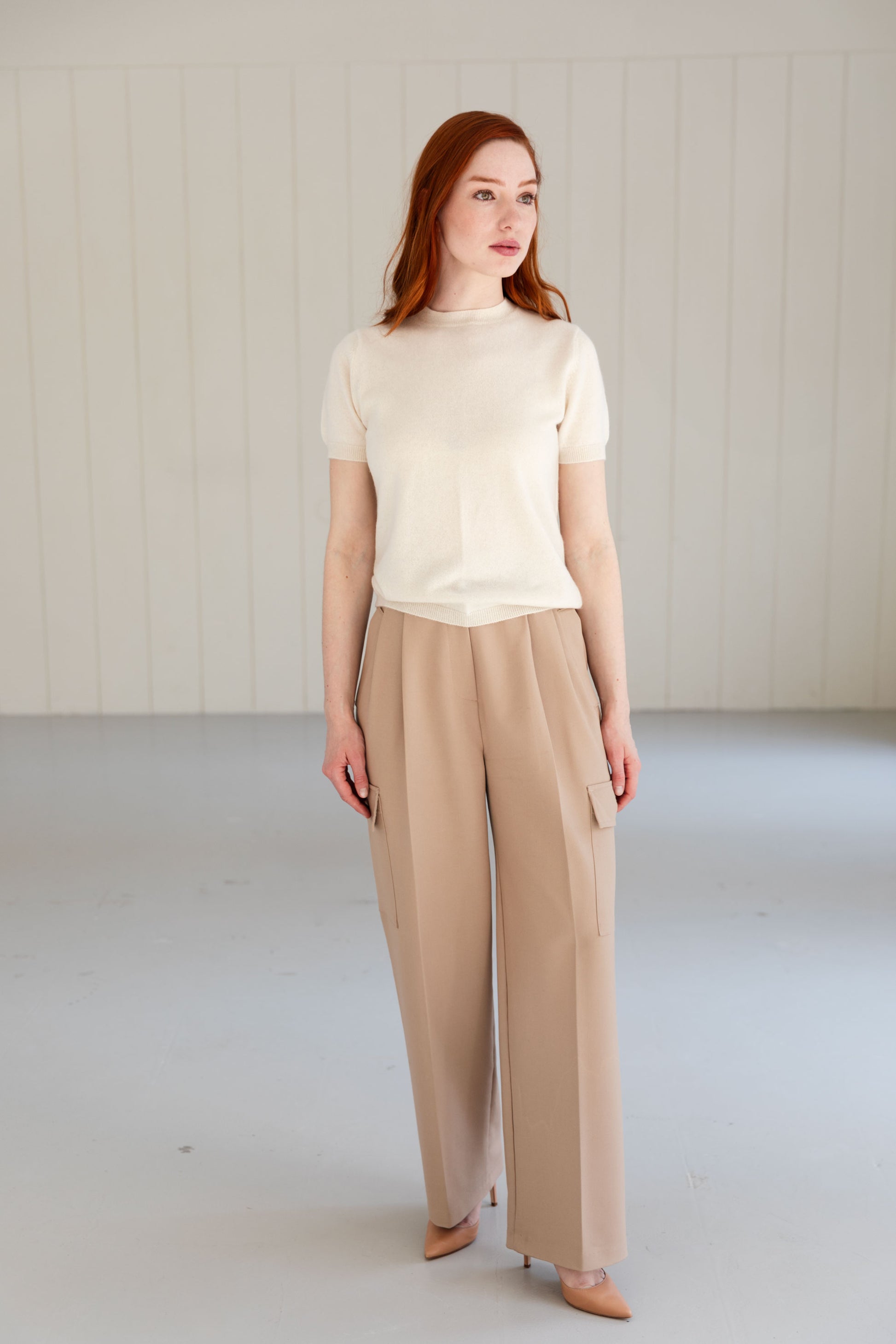 Woman wearing a 100% Mongolian cashmere t-shirt and beige elegant trousers.