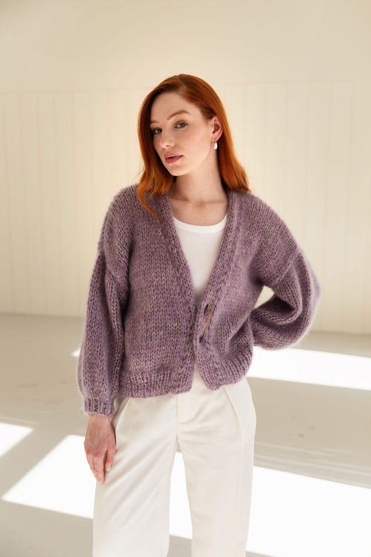 Woman wearing a purple mohair cardigan over a white top and pants