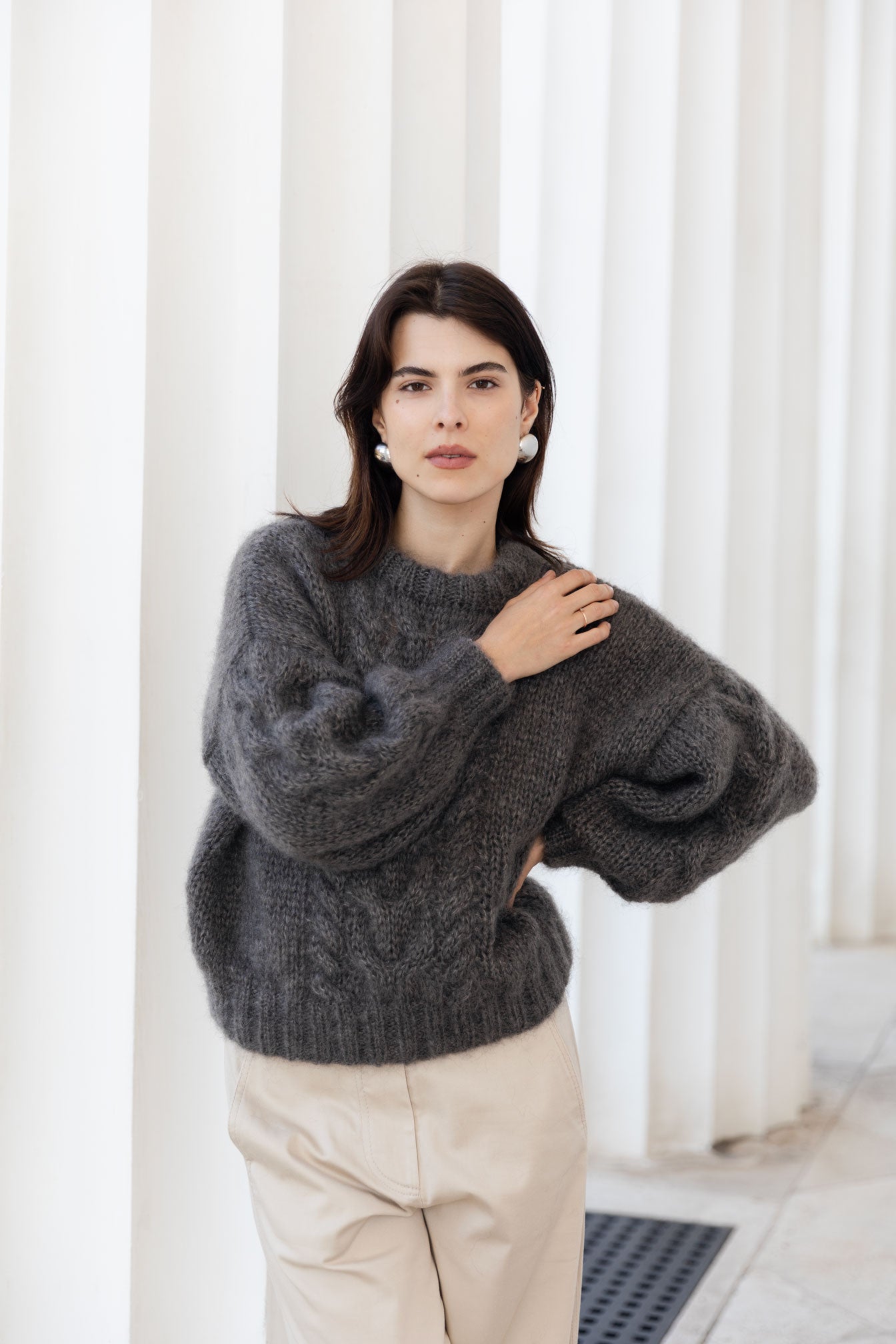Woman wearing a brown mohair-silk sweater against a white background