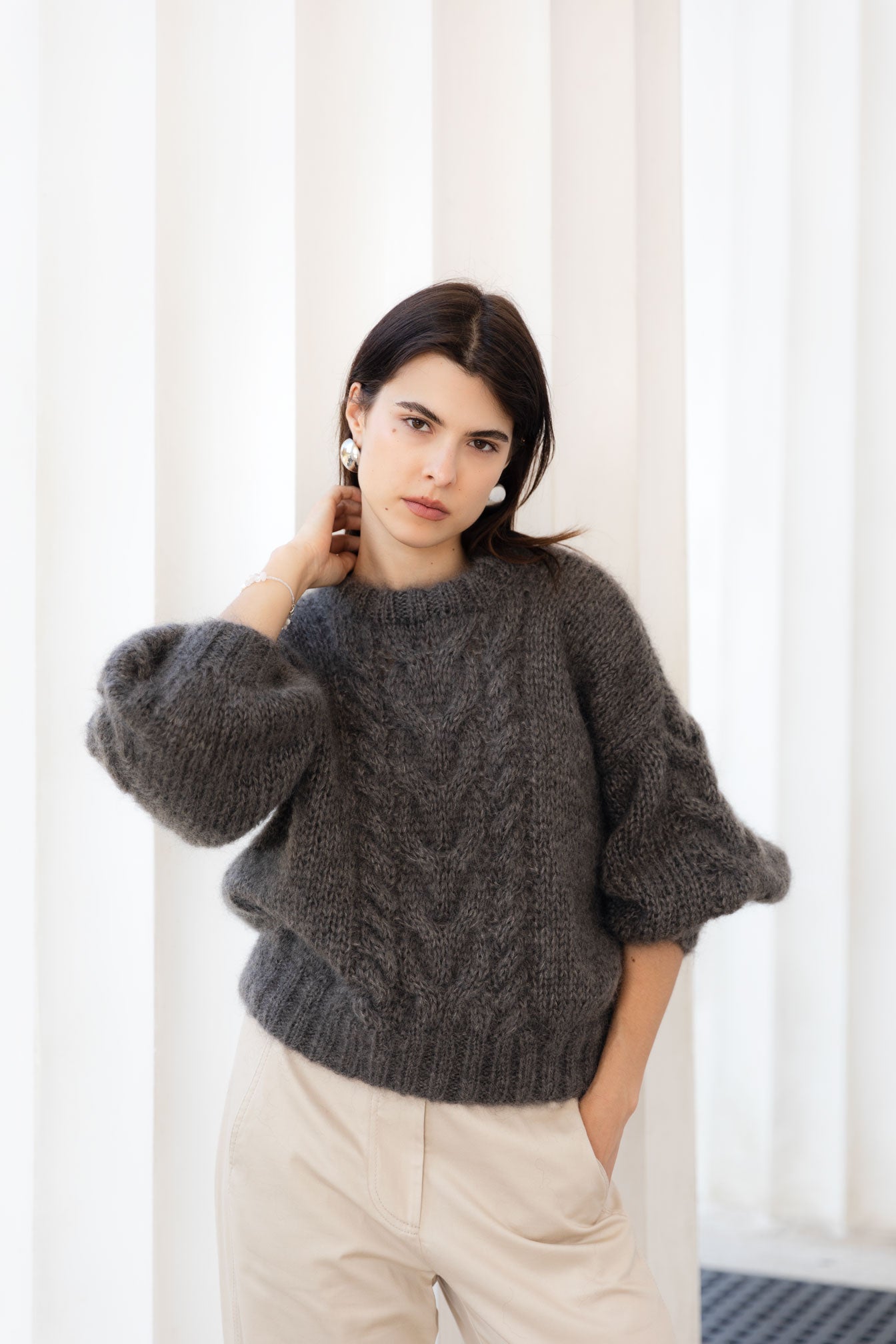 Woman wearing a brown mohair sweater with artisanal cable details