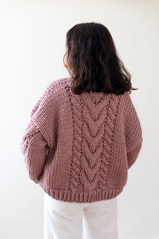 Handmade wool cardigan embellished with a cable knit pattern, pink color